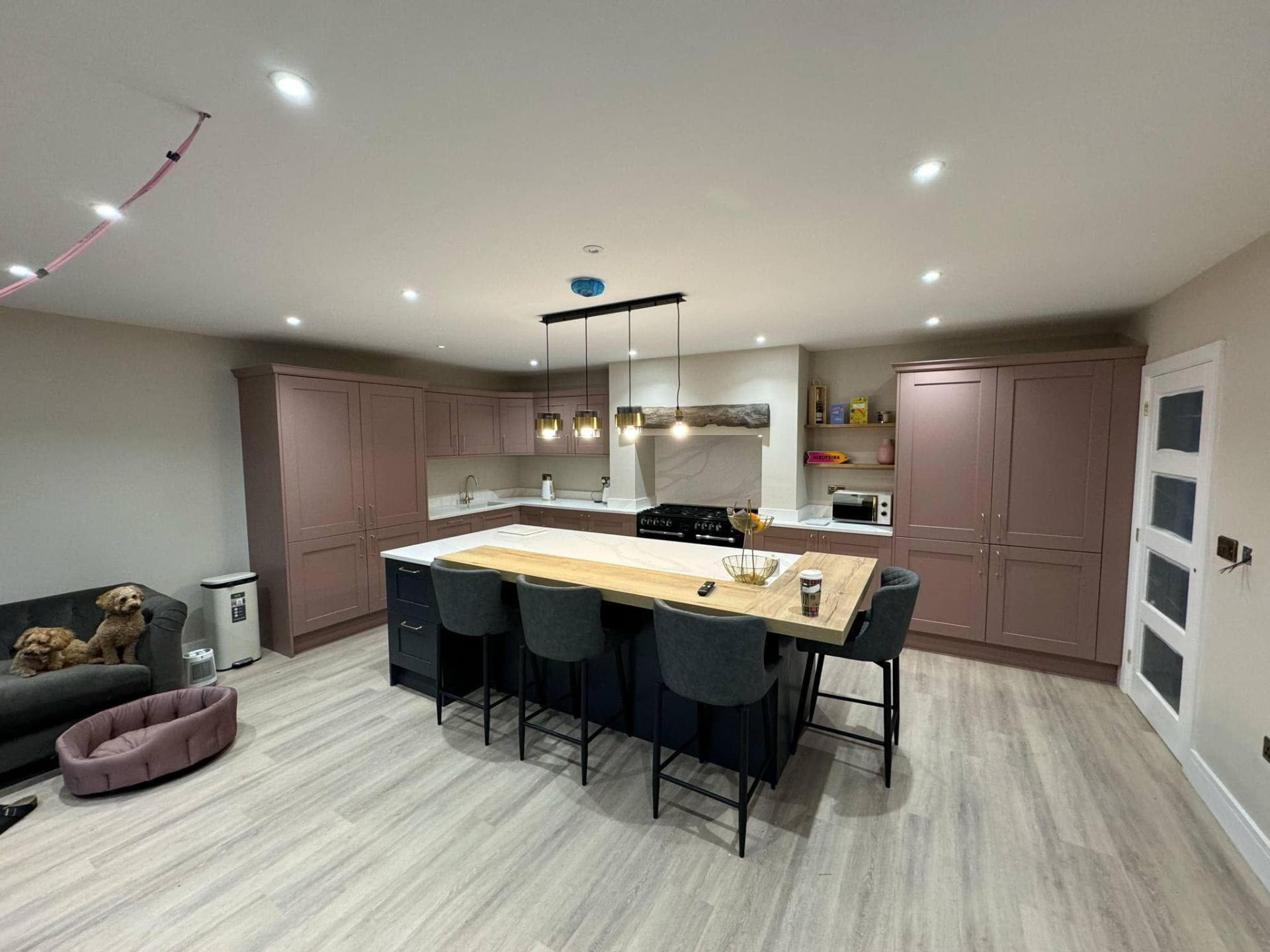 Dusky pink shaker kitchen with navy island & oak breakfast bar